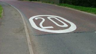 White road marking with 20 in a circle.