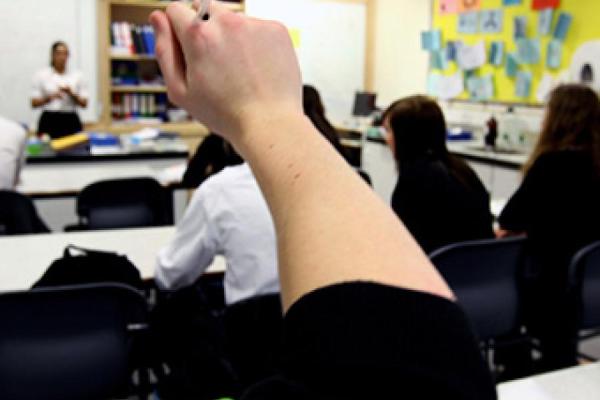 child with hand up in a class