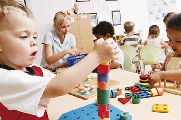 children playing with building blocks in a classroom