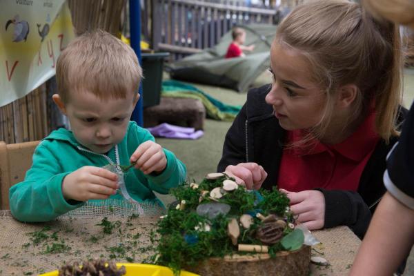 child playing with plant at a table