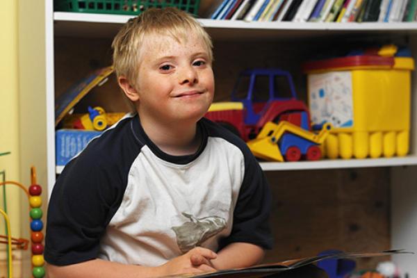 SEND child sitting and smiling in classroom