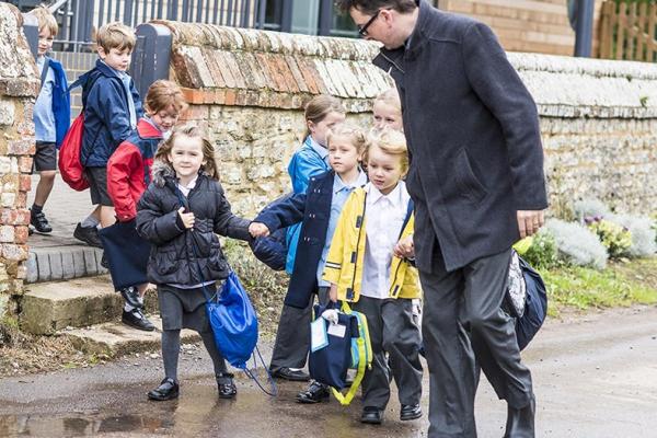 school children holding hands walking outdoors 